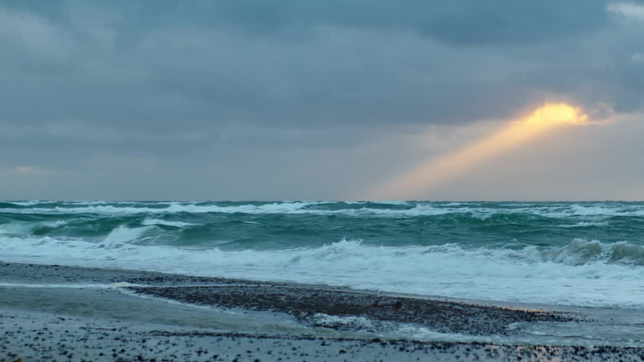 日落时海浪翻滚到海滩上视频素材