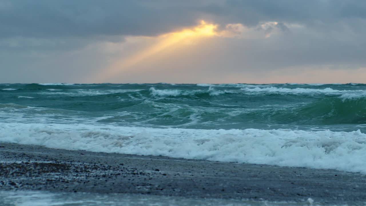 日落时海浪翻滚到海滩上视频素材