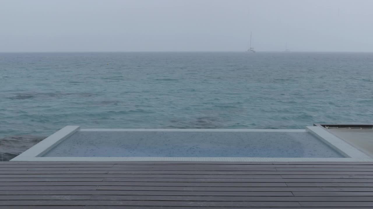 循环视频:雨在假期-豪华游泳池的视频而下雨和坏天气在假期度假旅行。无缝循环录像。视频素材