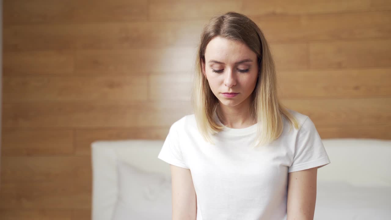 一名年轻女子正在看快速怀孕测试，并对不想要的阴性或阳性测试感到沮丧视频素材