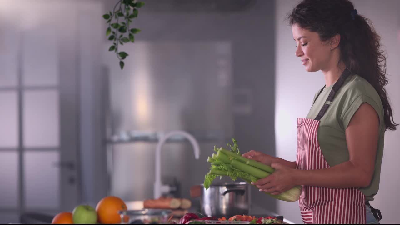 中年妇女在厨房里做饭。视频素材