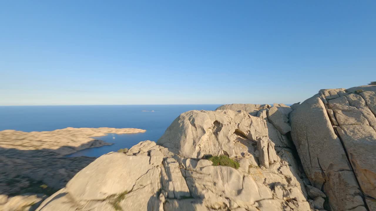 FPV视频，高山冲浪，在阳光明媚的日子在花岗岩上高速飞行。卡普拉岛，拉马达莱纳群岛，撒丁岛，意大利。视频素材