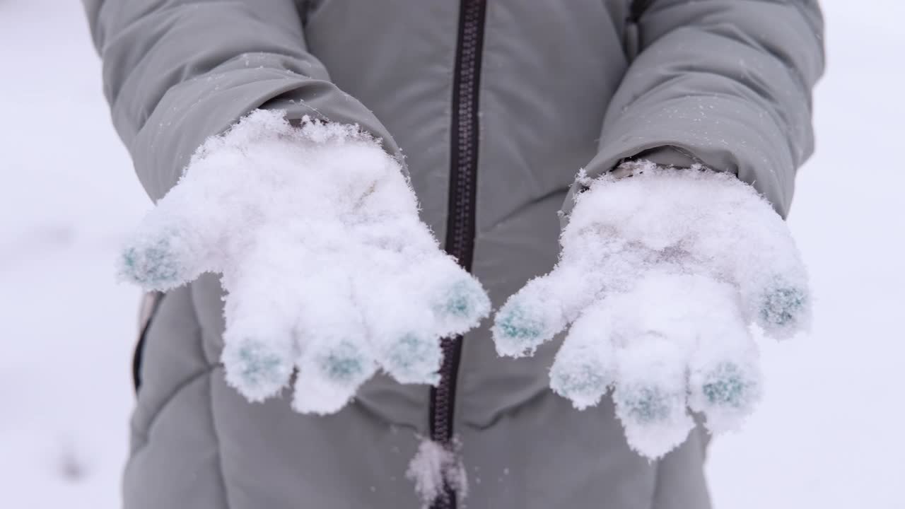 在雪花中戴上手套。视频素材