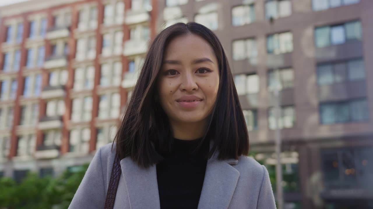 一个20多岁的亚洲女学生的肖像带着牙套微笑在城市视频素材