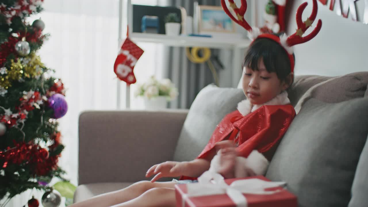 亚洲女孩在圣诞节打开礼品盒视频素材