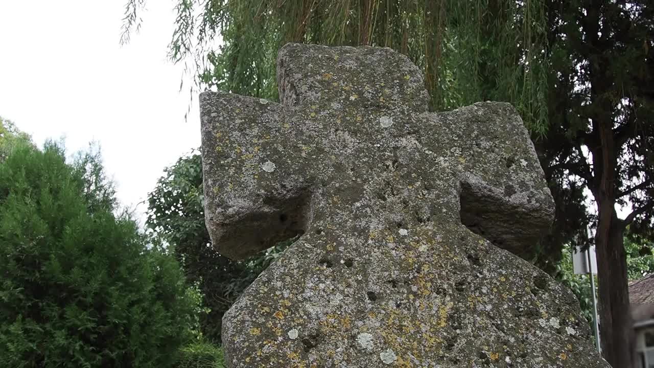 夏天的下午，墓地里的老石十字架。万圣节的主题。到达米特罗维察,塞尔维亚。长满青苔的十字架墓碑。一个怪异而神秘的地方。柳树摇曳。墓地之夜视频素材