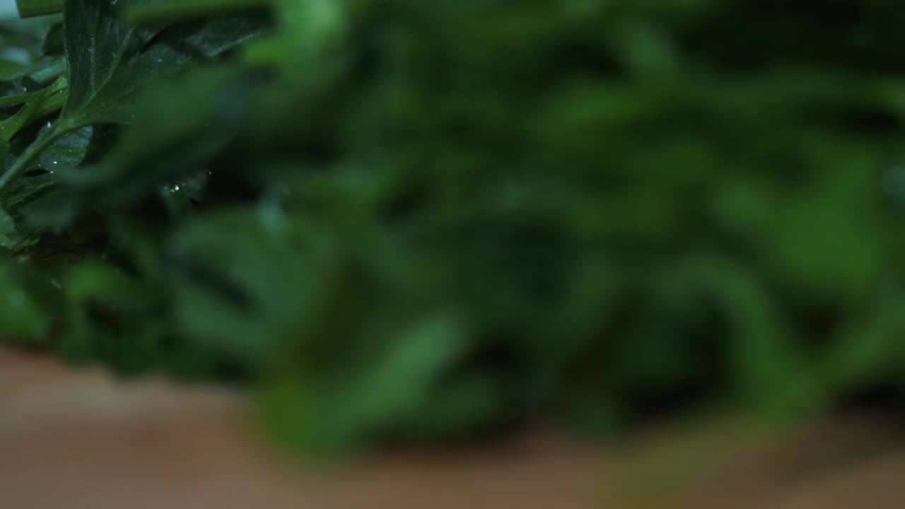 一个男人在厨房里切新鲜的香草做蔬菜沙拉视频素材