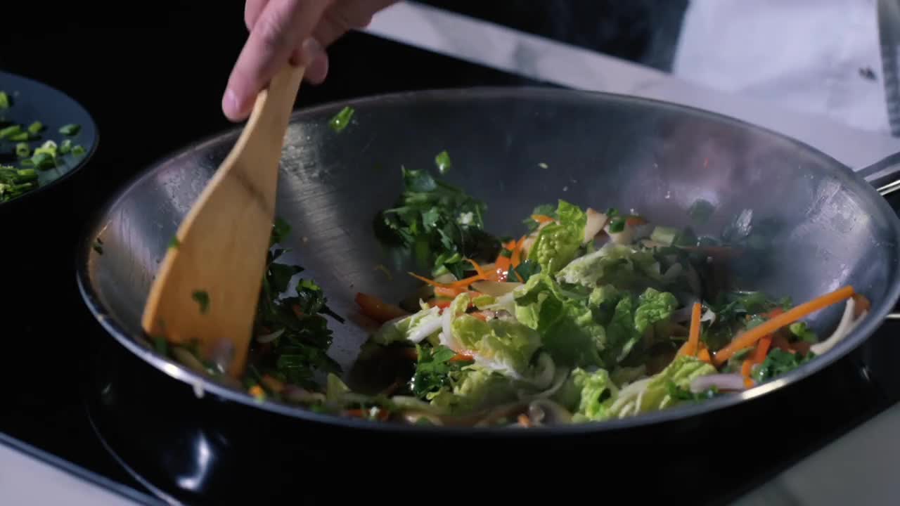 蔬菜与香草和香料在锅中炒。泛亚洲食品。视频素材