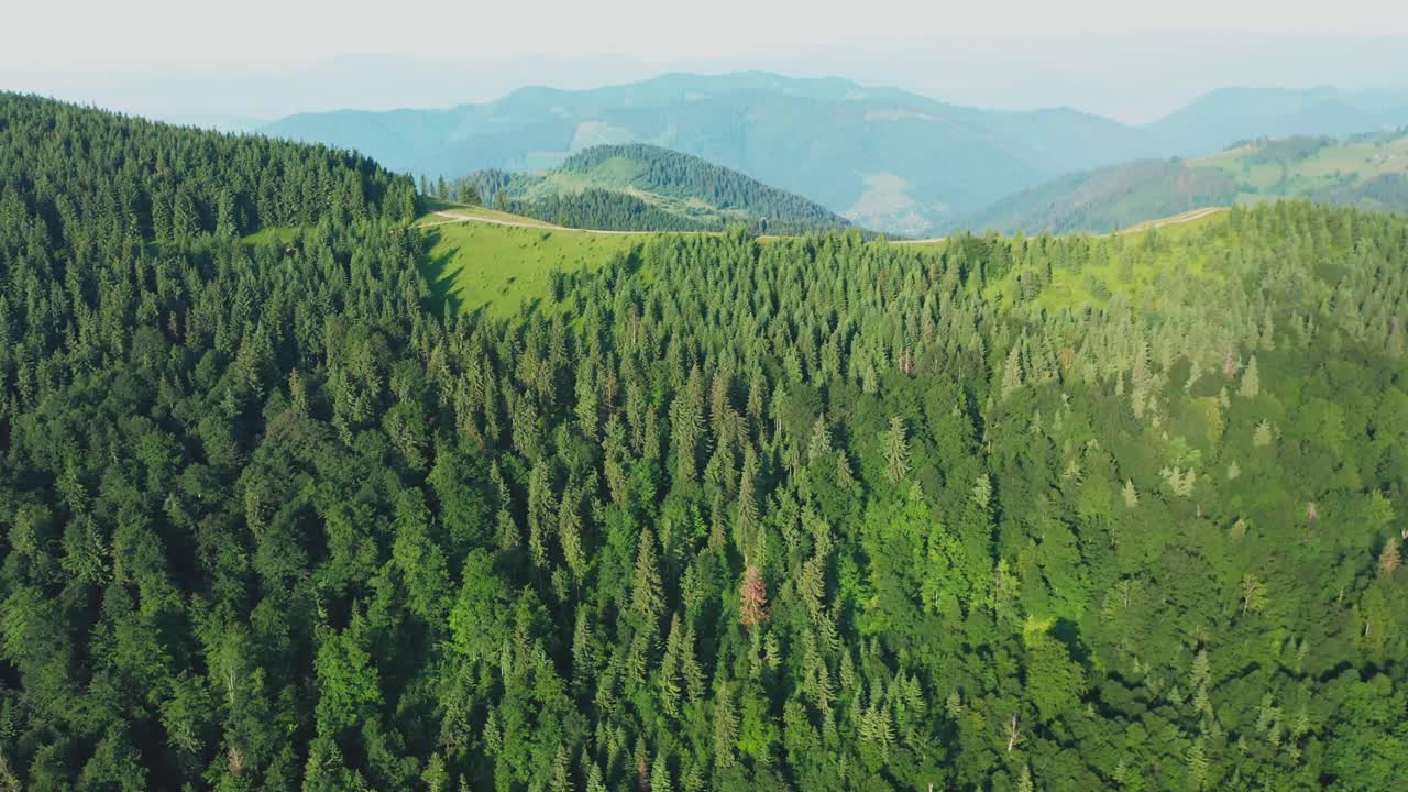 无人机拍摄的乡村公路穿过绿色的山丘视频素材