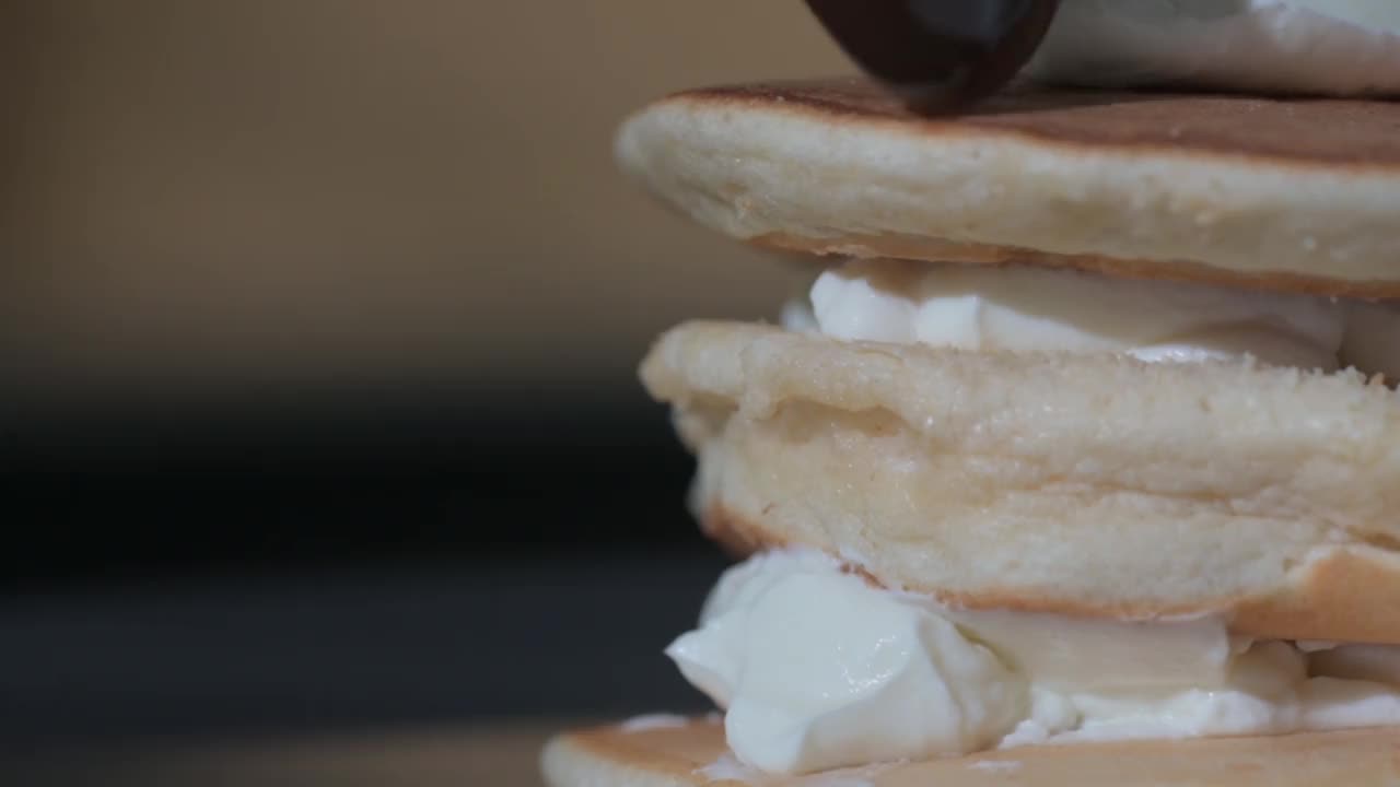 烹饪煎饼的特写镜头。厨师把热巧克力糖浆倒在甜点上视频素材