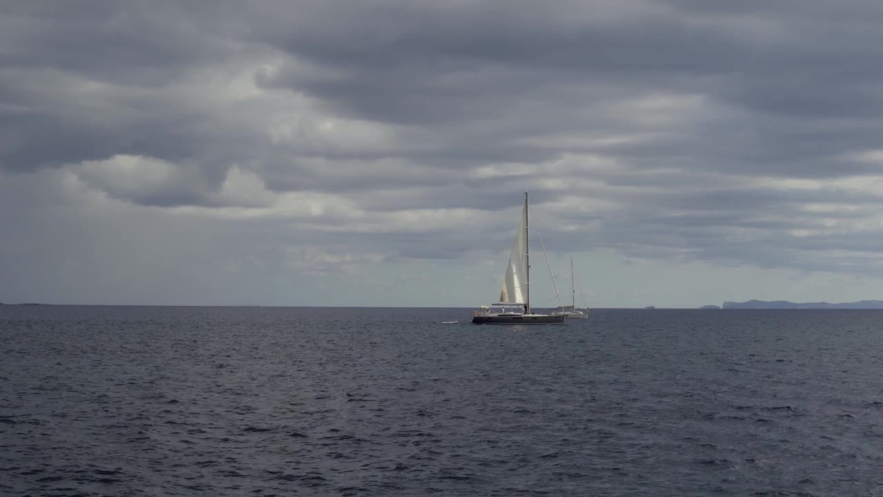 日落时的地中海海景，云朵和一艘船在它的水域中缓慢航行。西班牙马略卡岛的壮丽日落景观视频下载