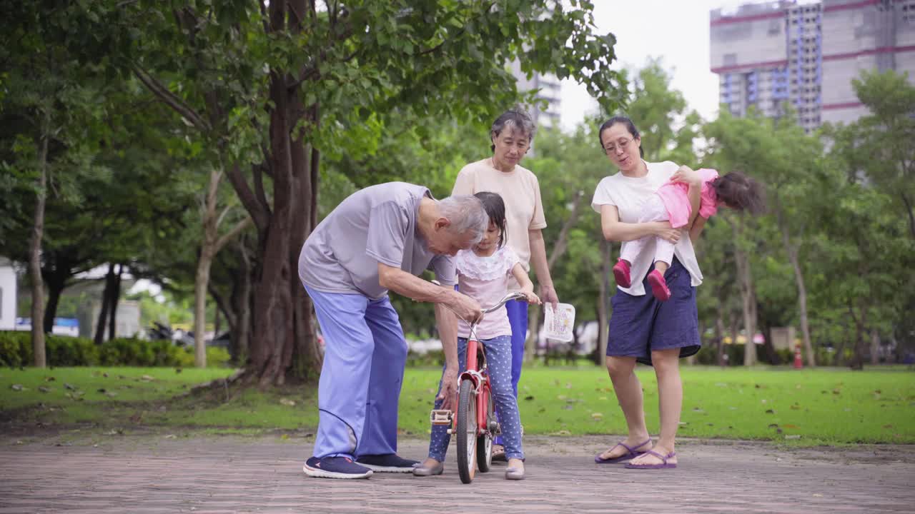 亚洲的祖父母教孙子骑自行车，与家人一起散步和锻炼视频素材