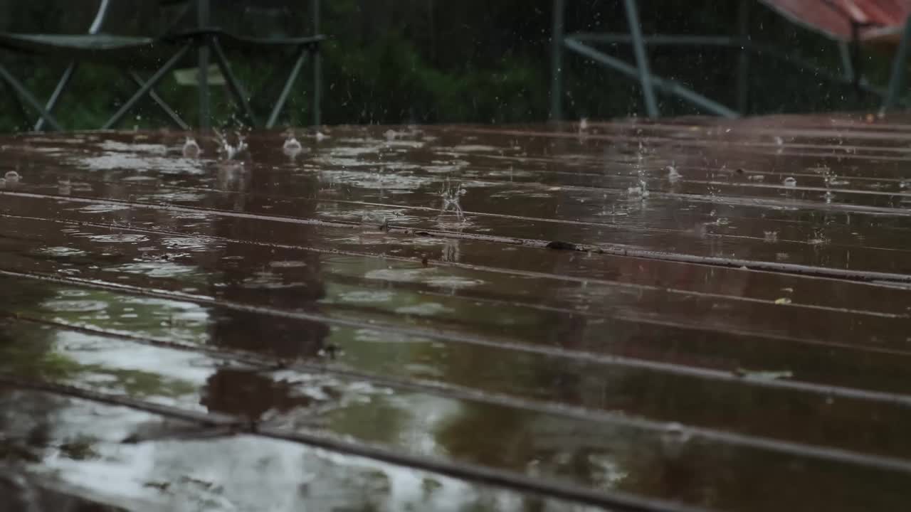 雨落在棕色木地板上的特写镜头。慢动作镜头视频素材