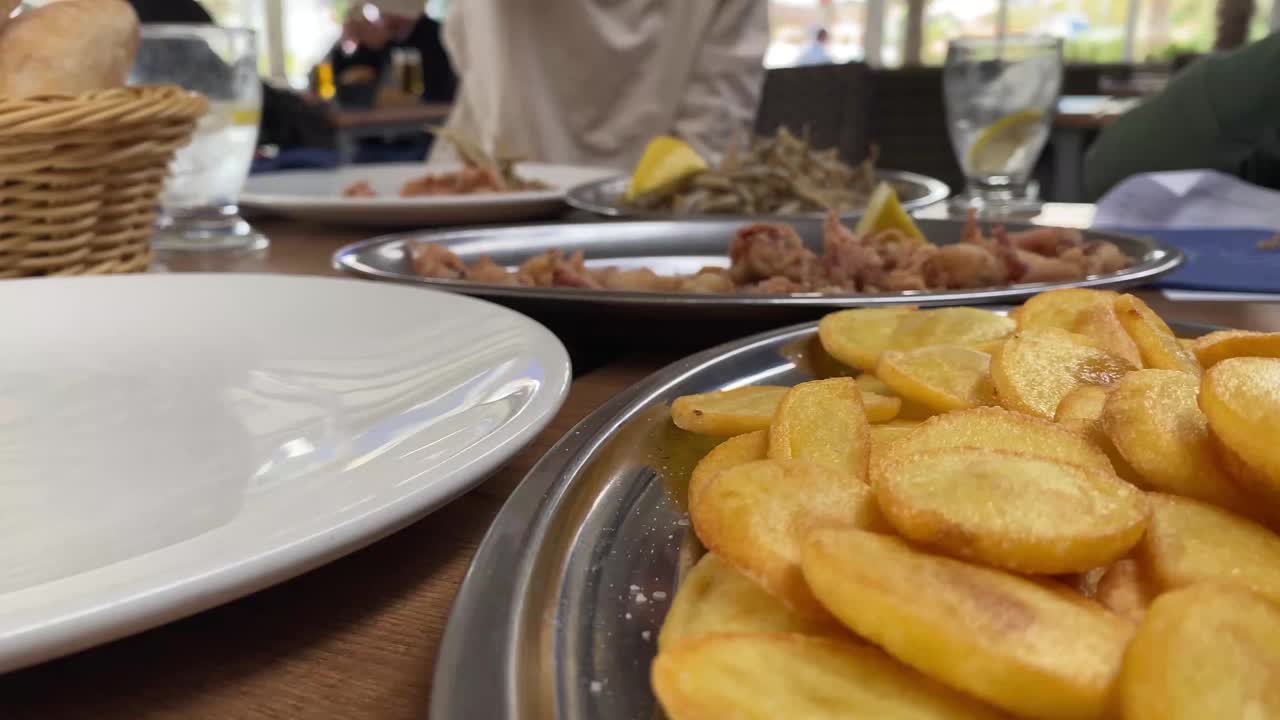 在西班牙餐厅和孩子们一起享用典型的西班牙炸鱼小食视频素材