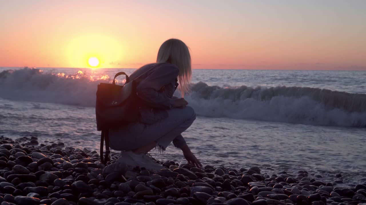 女孩坐在海边做梦。沿着美丽的海岸浪漫漫步。视频素材