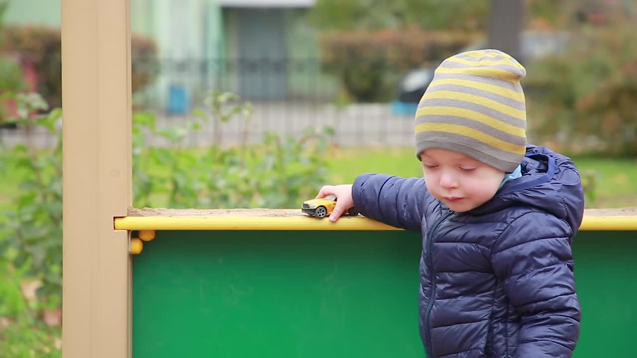 一个小孩在玩玩具车视频素材