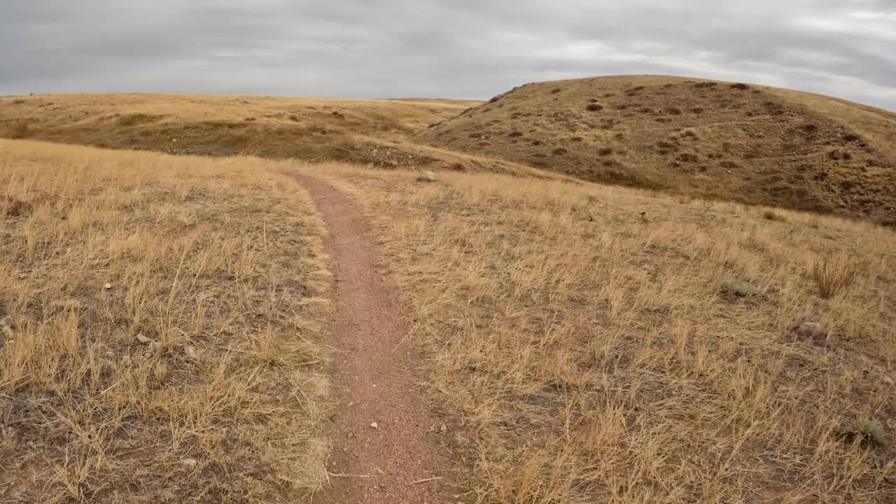 在科罗拉多大草原的一条单车道上骑山地车的POV视频素材