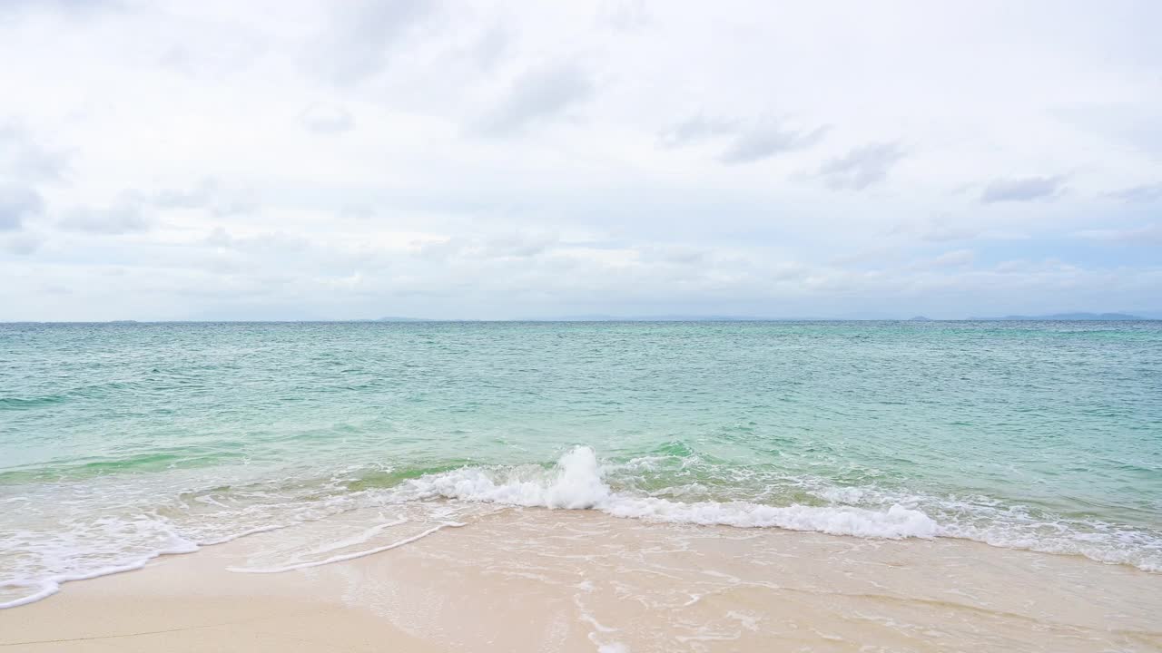 柔软的波浪与蓝色的海洋在沙滩上。视频素材