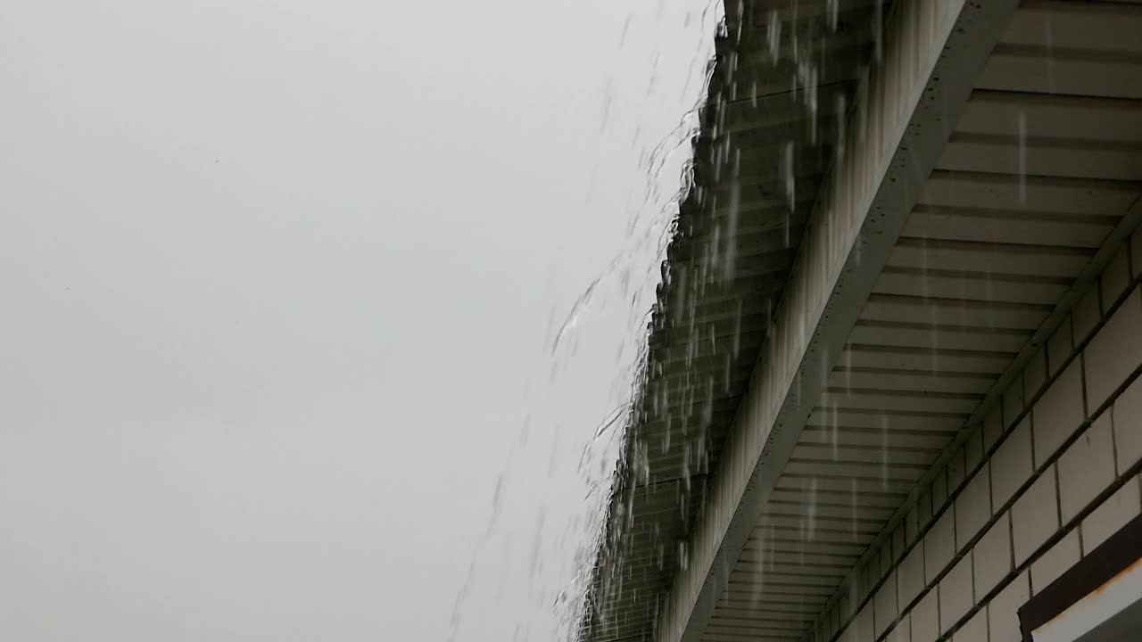 房子的屋顶是雨水。由暴雨引起的自然灾害。排水沟装置隐藏了在建的房屋。下午有大雨。有选择性的重点视频素材