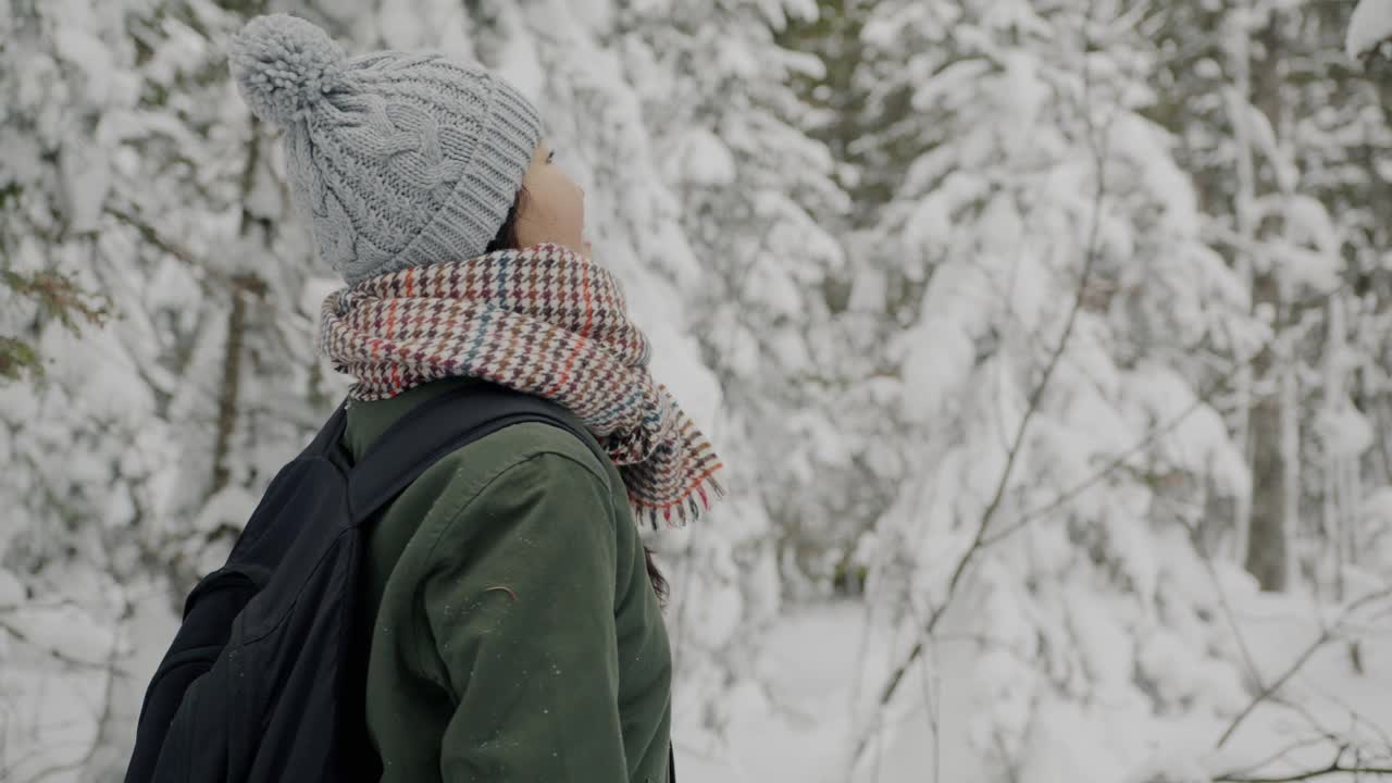 慢动作美丽的亚洲女人与雪户外在冬天的树林视频素材