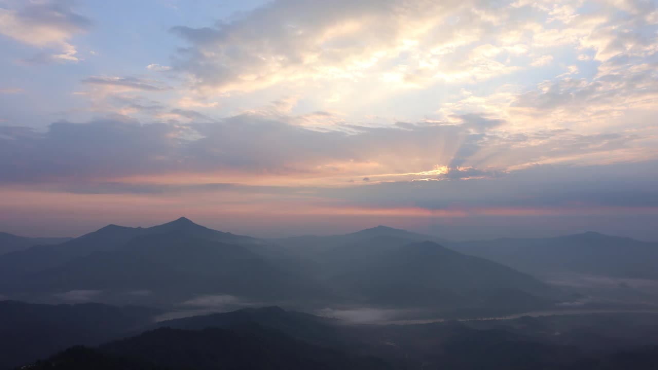 日出时，从地平线上的山顶上看到的景色，背景是一条河和一片薄雾的海洋。泰国清莱省翁坚区帕唐视点视频素材