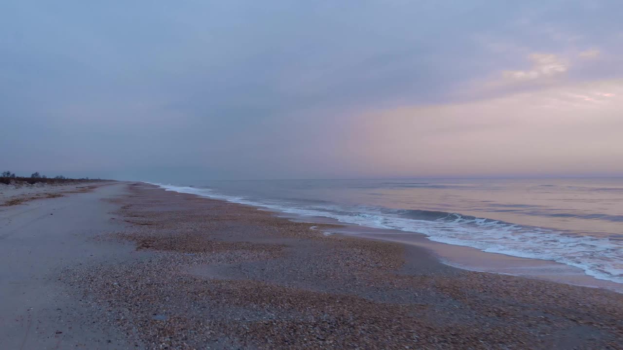 空旷的沙滩，日出时波浪翻滚。热带海滩上的海洋日落视频素材