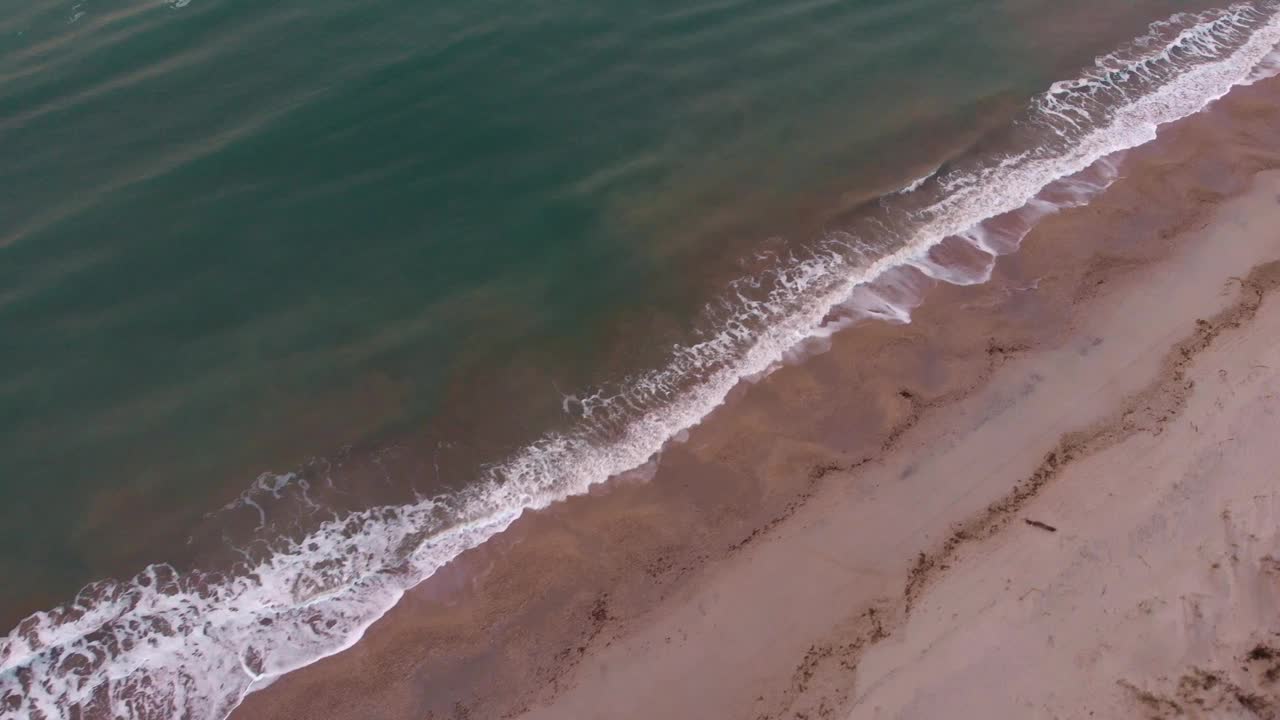 海浪拍打着沙滩。热带海洋风景。海边的日出。海浪带着白色的泡沫到达金色的海滩视频素材