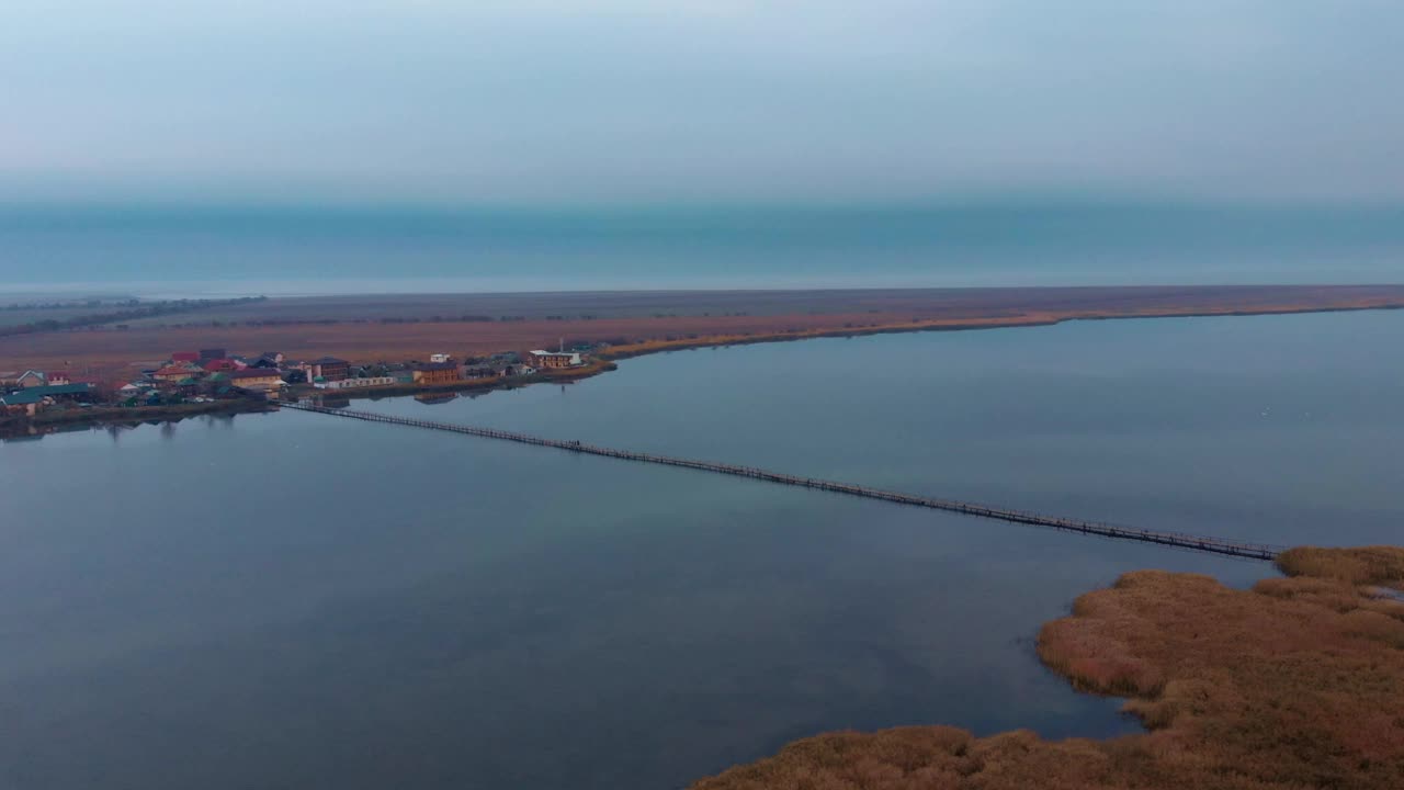 日出时，河口空无一人。美丽的海上景观。野生自然。空人行桥通过河口视频素材