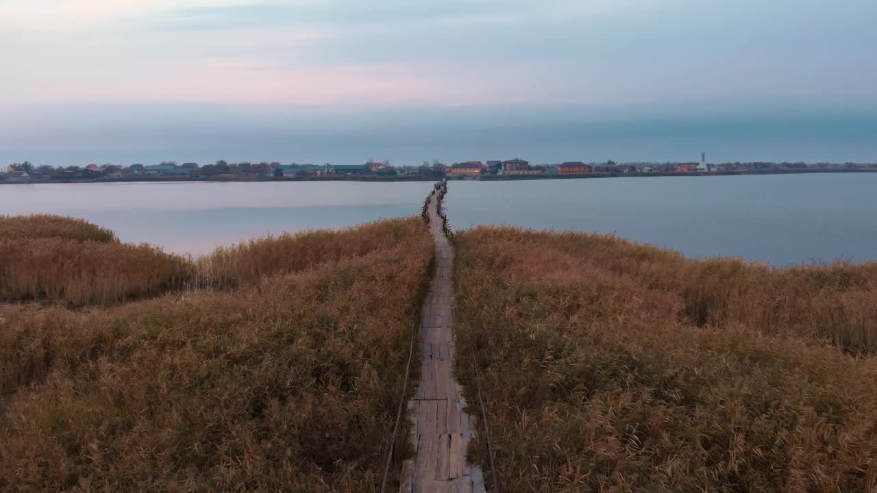 空桥通过河口或湖。美丽的日出在河口。野生自然景观。日落时平静的湖面视频素材