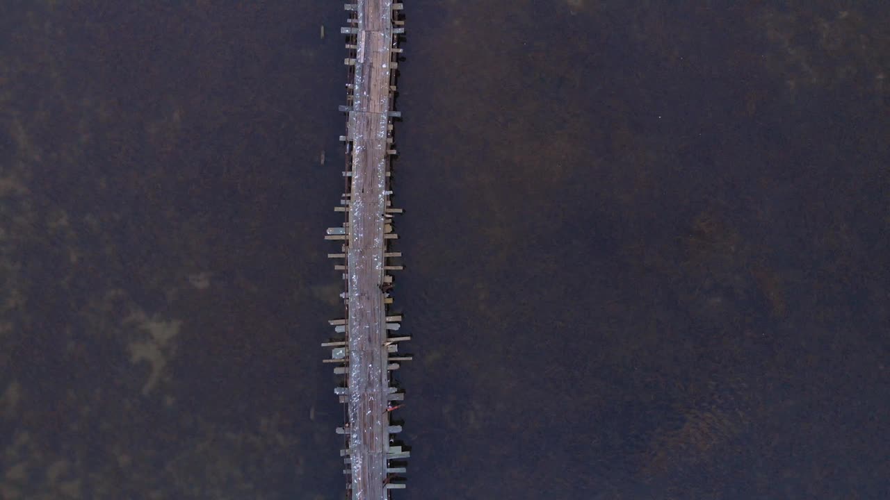 古老的钓鱼木桥上湖与宁静的清澈的水。海景。平静的水面。湖上美丽的日出。野生自然景观视频素材