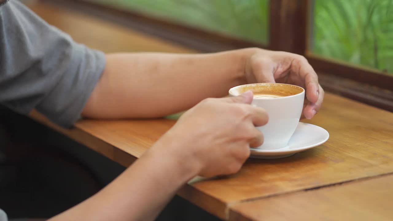 4K特写:亚洲男人在咖啡馆用咖啡杯喝咖啡视频素材