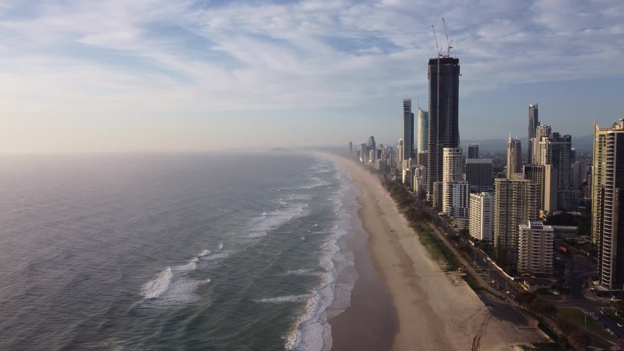 冲浪者在清晨的天堂海滩和高楼大厦。黄金海岸,澳大利亚,视频素材