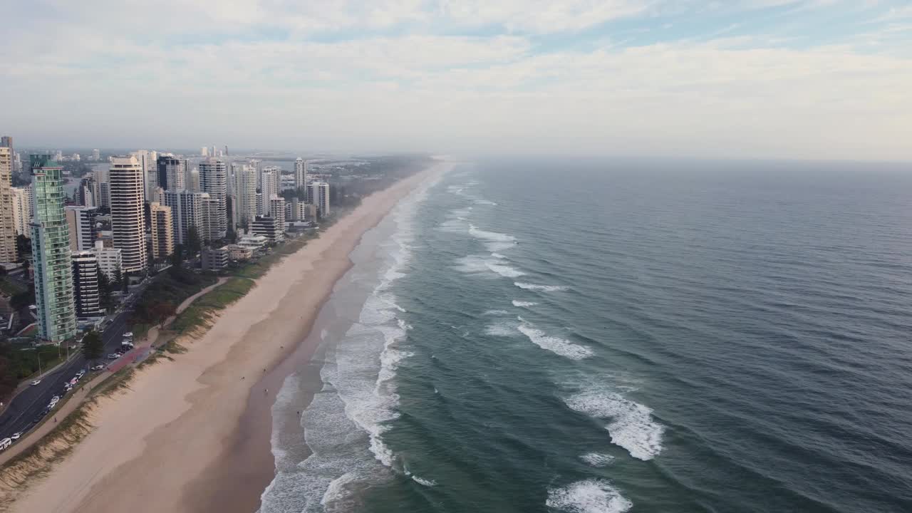 冲浪者在清晨的天堂海滩和高楼大厦。黄金海岸,澳大利亚,视频素材