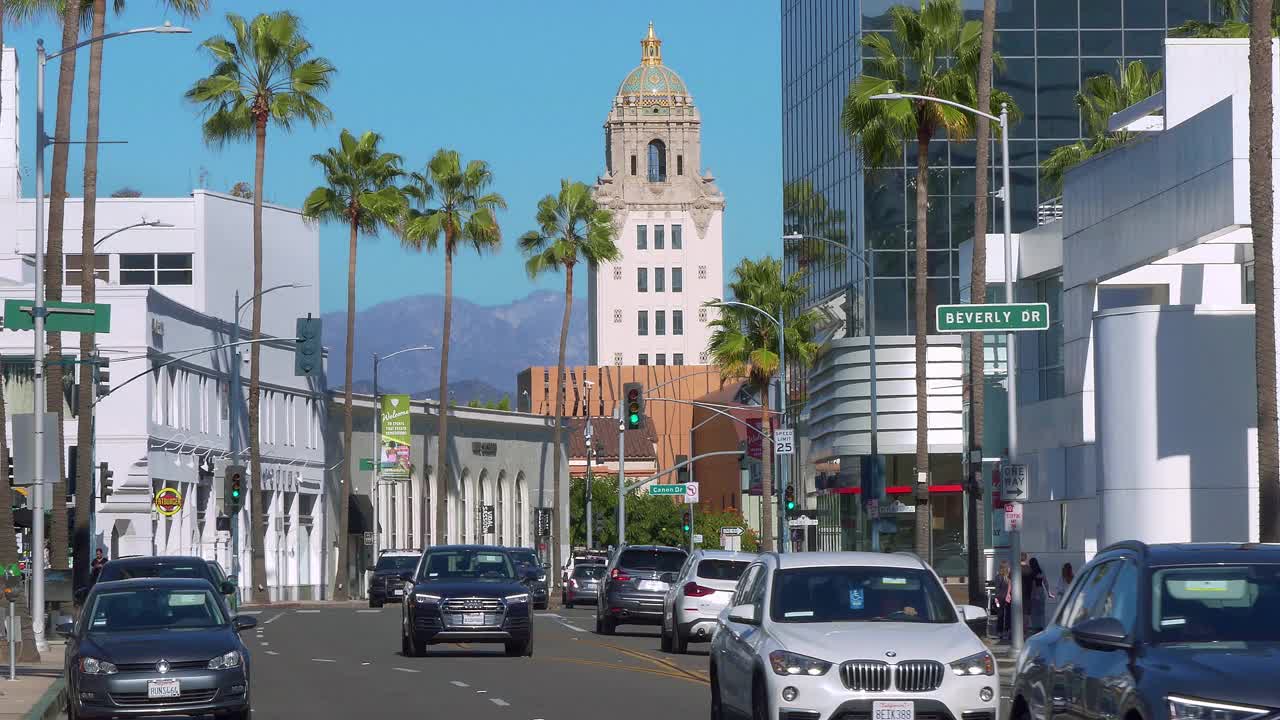 豪华车和警车行驶在加州洛杉矶比弗利山市政厅附近的圣莫尼卡大道上，4K视频素材