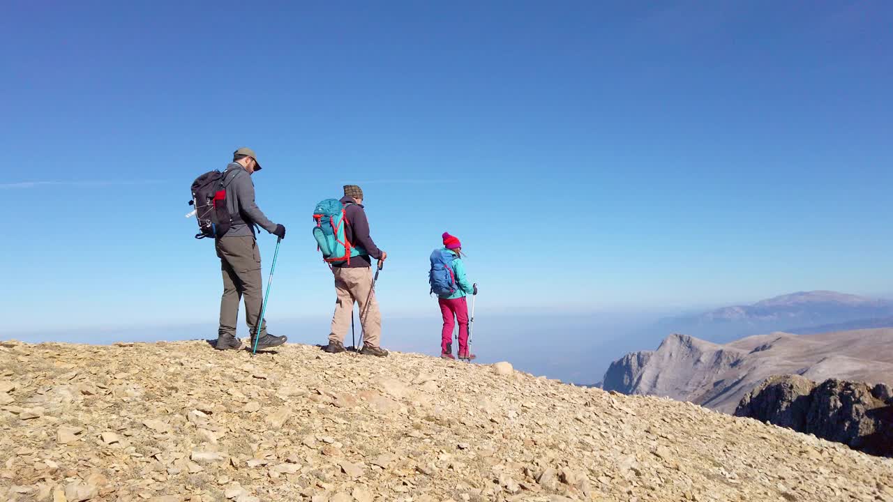 成功的登山队员队伍正在攀登山脊的山顶。视频素材