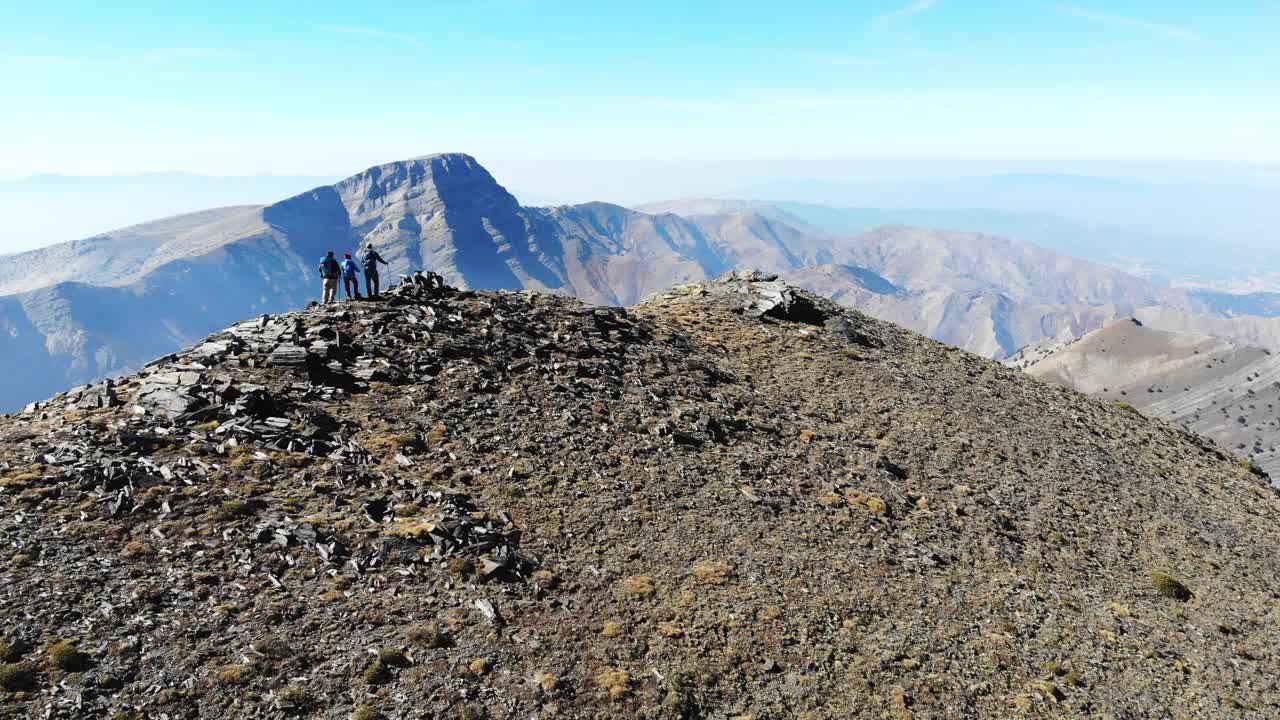 无人机拍摄的成功登山队正在攀登山脊的山顶。视频素材