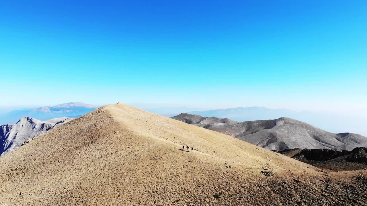 无人机拍摄的成功登山队正在攀登山脊的山顶。视频素材