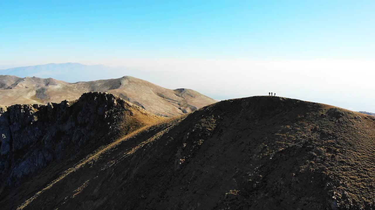 无人机拍摄的成功登山队正在攀登山脊的山顶。视频素材