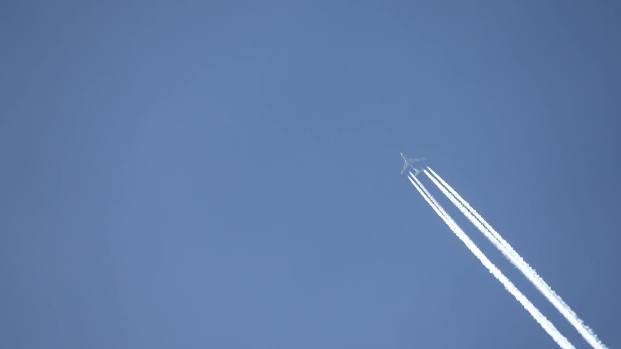 高空飞行的喷气式客机在清澈的蓝天上留下了尾迹。视频素材