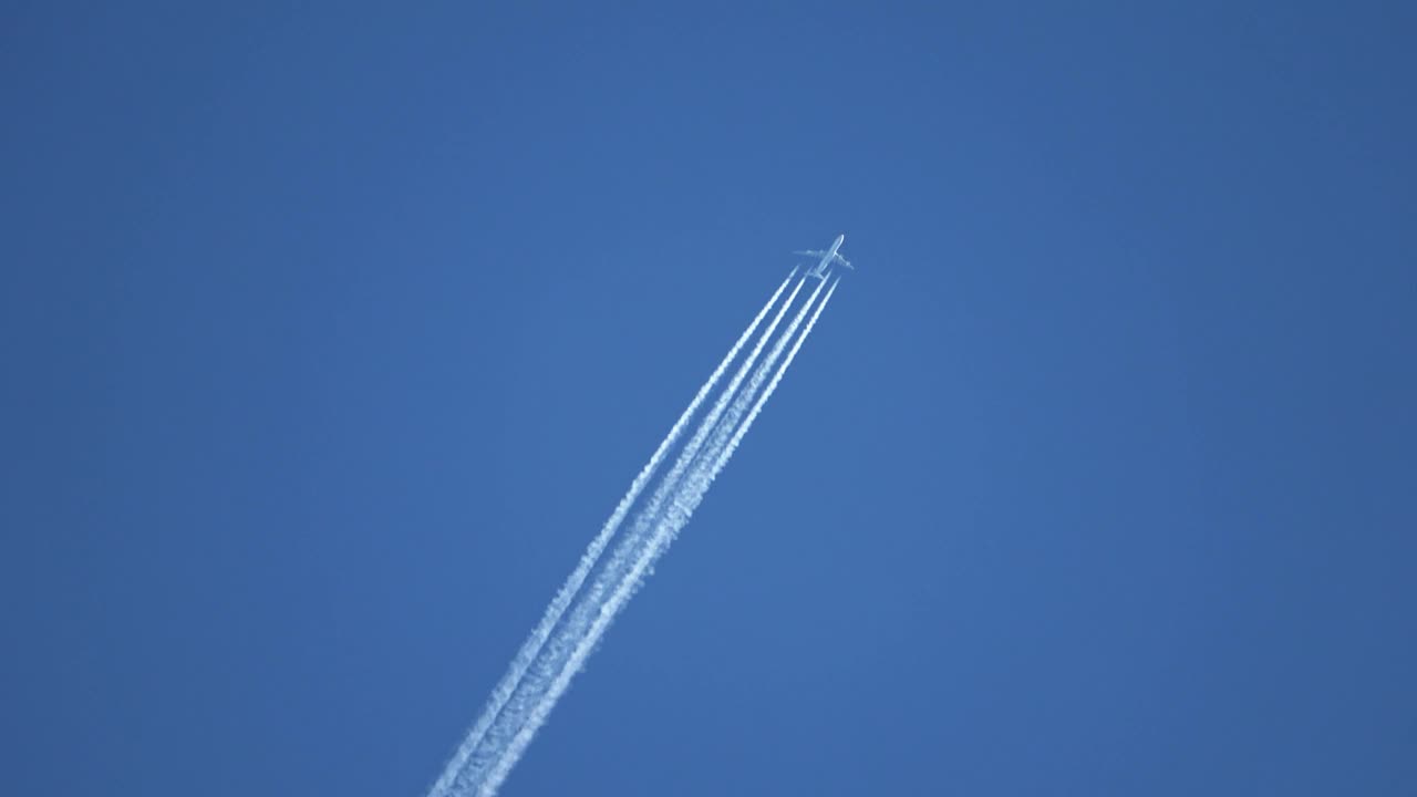 高空飞行的喷气式客机在清澈的蓝天上留下了尾迹。视频素材