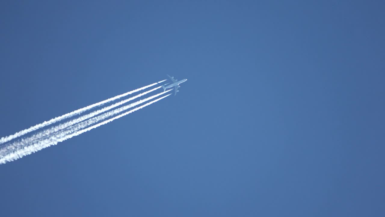 高空飞行的喷气式客机在清澈的蓝天上留下了尾迹。视频素材