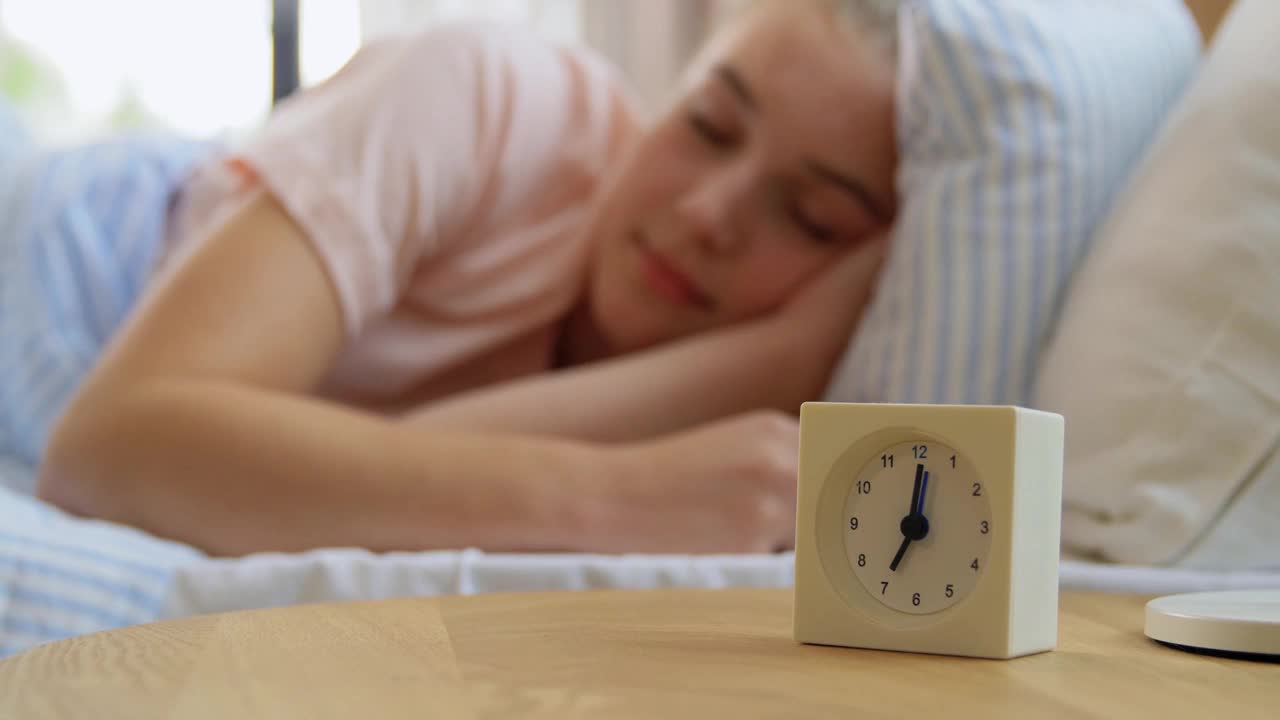 闹钟在床上醒着的瞌睡女孩视频素材