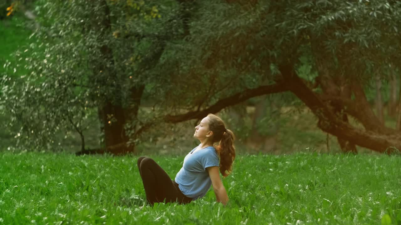 女运动员穿着运动服做瑜伽练习。年轻的女士正在做瑜伽视频素材