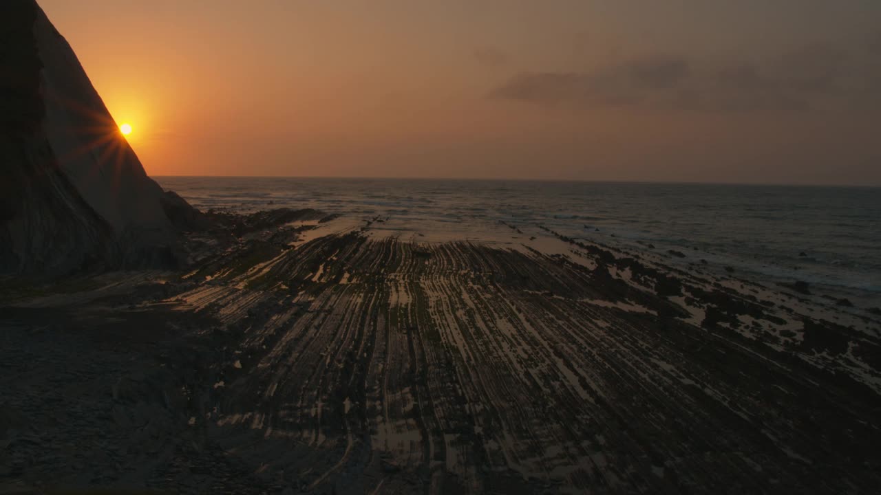 夕阳西下时，太阳藏在山后的海洋里视频素材