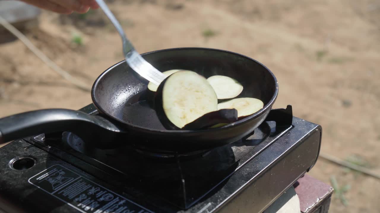 在煤气炉上煎茄子。烹饪视频素材