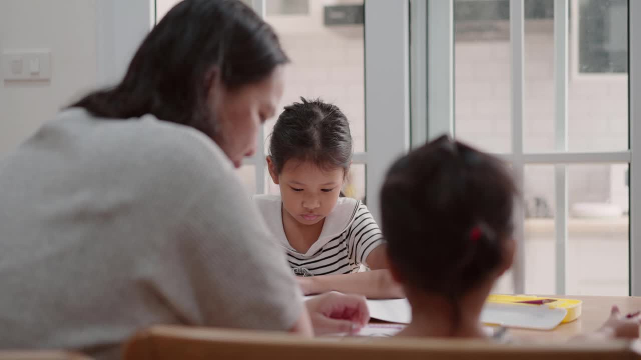 母亲照顾两个女儿在家学习，照顾姐姐视频素材