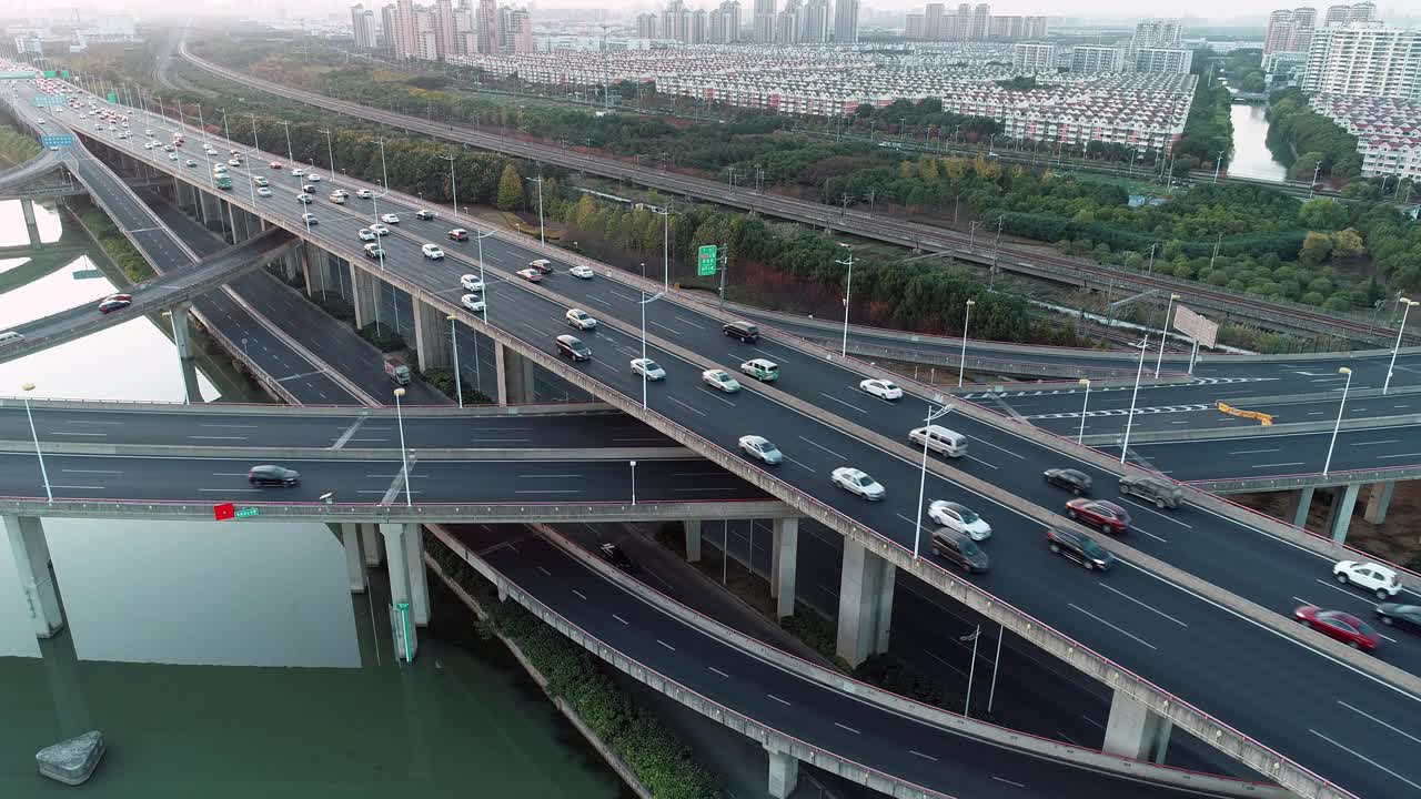 鸟瞰图的道路交叉口与移动的汽车。道路立交或高速公路交叉路口，城市交通繁忙，在道路上超速行驶。视频素材