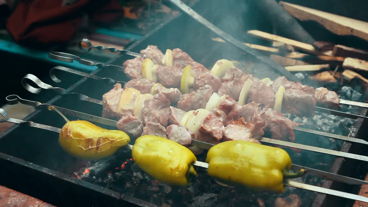 用烤架烹调肉和蔬菜。烧烤在自然界中。烟熏的烤肉串。热的食物。视频素材