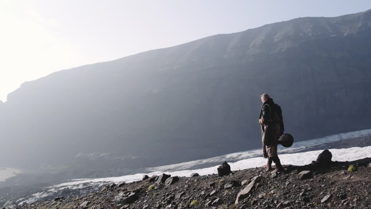 旅行者徒步从冰川的岩石山坡上下来视频素材