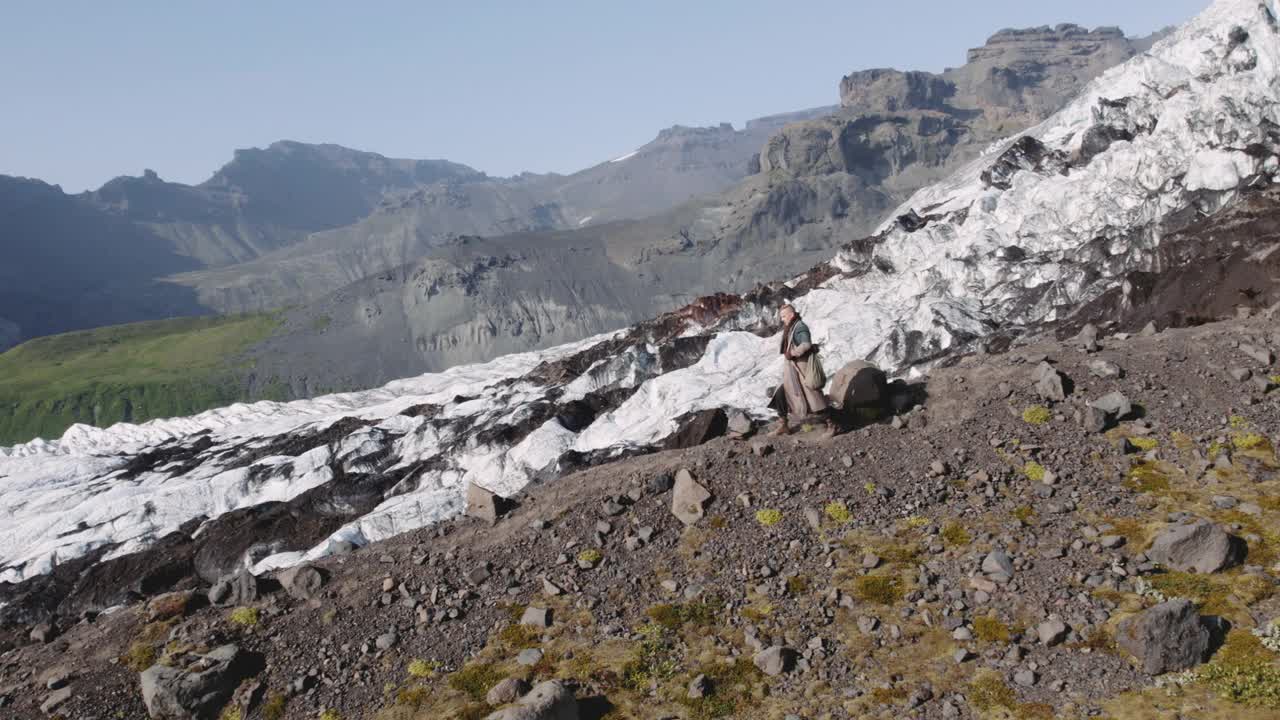 旅行者徒步从冰川的岩石山坡上下来视频素材